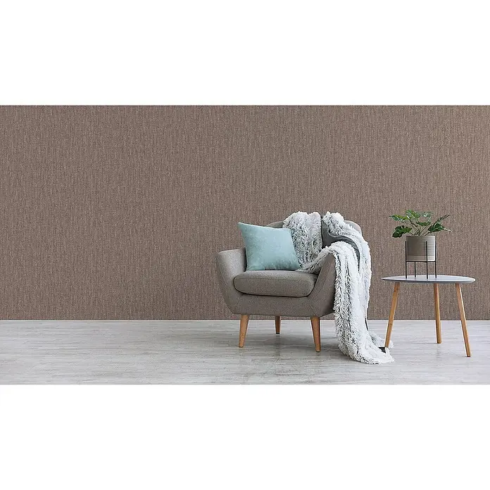 Tadessi Vliestapete M1-No.3405 - Braun, Sonstiges, 10,05 x 0,53 m - Braune strukturierte Tapete an einer Wand, die eine warme Raumkulisse mit Sessel und Beistelltisch bildet.
