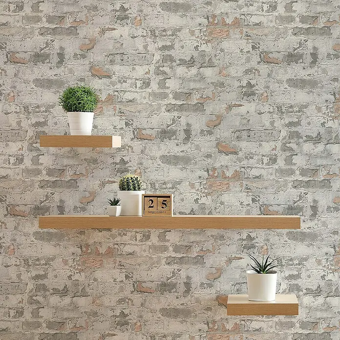 Tadessi Vliestapete M1-No.292 - Grau, Steinoptik, 10,05 x 0,53 m - Drei schwebende Regale aus hellem Holz an einer Wand, die Pflanzen und einen Kalender halten.