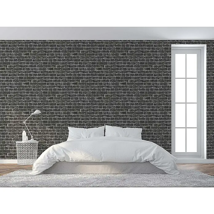 Tadessi Vliestapete M1-No.45 - Schwarz, Steinoptik, 10,05 x 0,53 m - Dunkelgraue Ziegelstein-Tapete an einer Akzentwand in einem modernen Schlafzimmer, mit weißem Bett und großem Fenster.