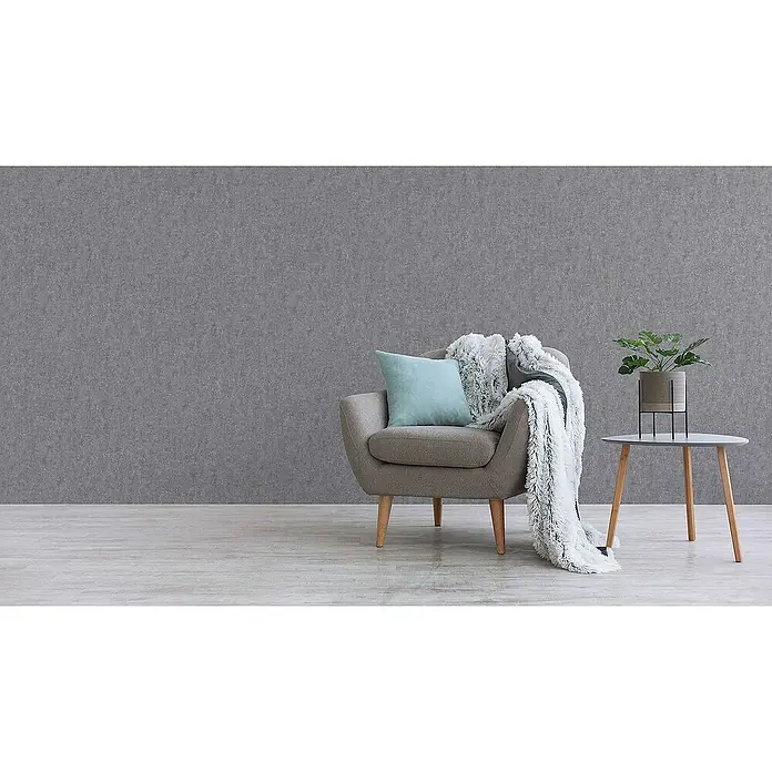 Tadessi Vliestapete M1-No.1813 - Grau, Steinoptik, 10,05 x 0,53 m - Ein gemütlicher Wohnbereich mit grauem Sessel, blauem Kissen und flauschiger Decke, Beistelltisch mit Topfpflanze.