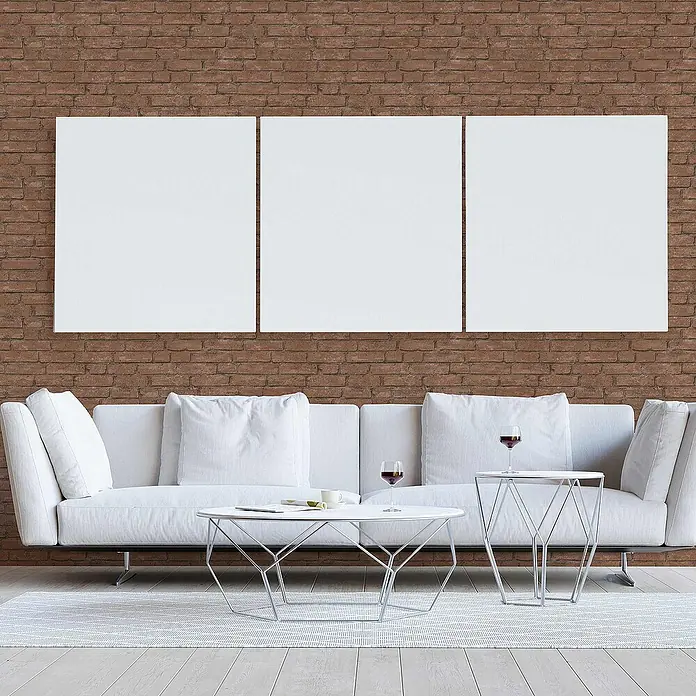 Tadessi Vliestapete M1-No.3243 - Orange, Steinoptik, 10,05 x 0,53 m - Drei leere, weiße, rechteckige Leinwände hängen nebeneinander an einer Ziegelwand, bereit für Kunst.