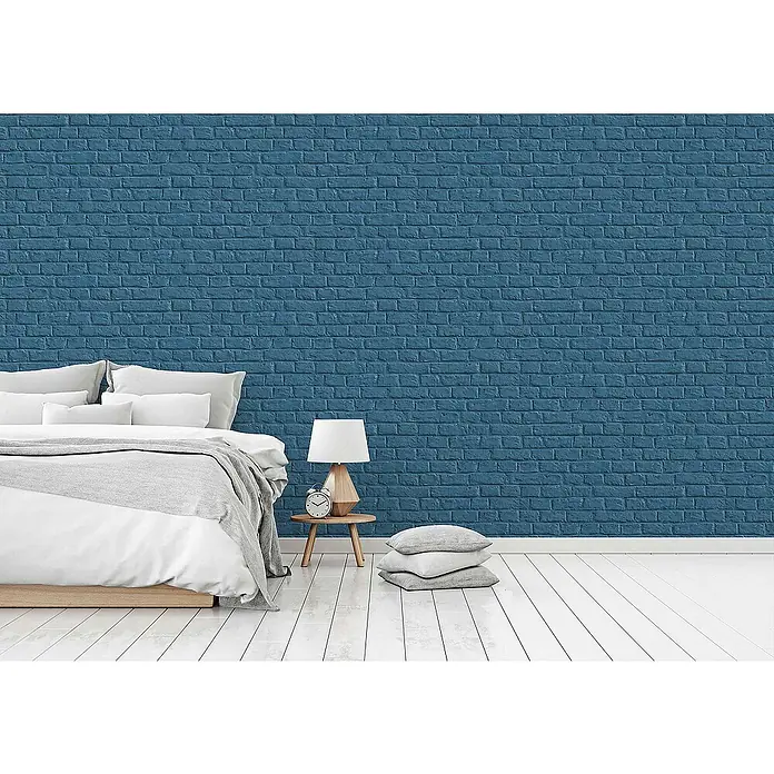 Tadessi Vliestapete M1-No.1568 - Blau, Steinoptik, 10,05 x 0,53 m - Blaue Ziegelstein-Tapete bedeckt eine Schlafzimmerwand hinter einem Bett und Nachttisch. Realistisches strukturiertes Design.