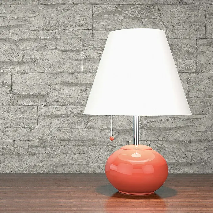 Tadessi Vliestapete M1-No.850 - Grau, Steinoptik, 10,05 x 0,53 m - Korallfarbene Keramik-Tischlampe mit weißem Schirm auf einer Holzoberfläche.