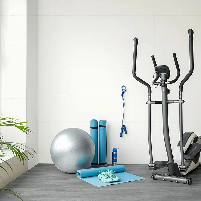 Revêt Wandpaneel SPC Wall - 600 x 300 mm, Weiß, Hochglänzend - Fitnessraumausstattung mit einem Ellipsentrainer, einem Gymnastikball, Yogamatten, Springseil, Wasserflasche und Turnschuhen.