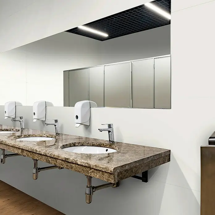 Revêt Wandpaneel SPC Wall - 600 x 300 mm, Weiß, Hochglänzend - Ein Marmorwaschtisch mit drei Waschbecken, Armaturen und Seifenspendern in einem modernen Badezimmer.