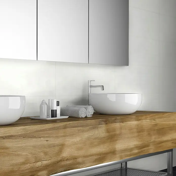 Revêt Wandpaneel SPC Wall - 600 x 300 mm, Weiß, Hochglänzend - Ein Badezimmerwaschtisch aus Holz mit zwei weißen Aufsatzwaschbecken und einem modernen Wasserhahn unter einem Spiegelschrank.