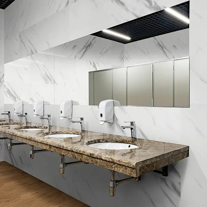 Revêt Wandpaneel SPC Wall - 1.200 x 600 mm, Marmor Weiß, Hochglänzend - Elegante Waschbecken mit Marmorplatte, Seifenspendern und stilvollen Armaturen in einem modernen Badezimmer.