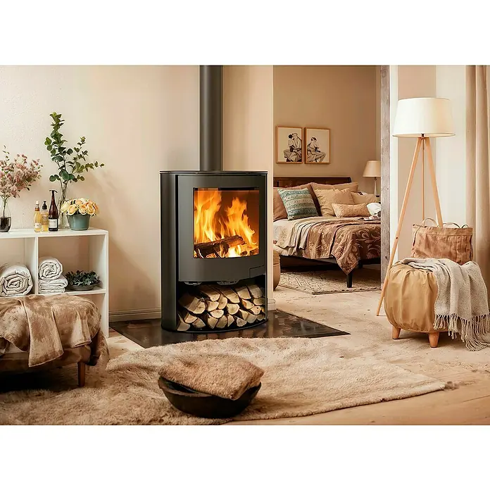 Panadero Kaminofen Tahoe - 6,7 kW, Raumheizvermögen: 200 m³, Material Verkleidung: Stahl, Schwarz Metallic - Gemütliches Wohnzimmer mit einem Kaminofen, der Wärme und Behaglichkeit ausstrahlt, umgeben von stilvoller Einrichtung und sanften Farbtönen.