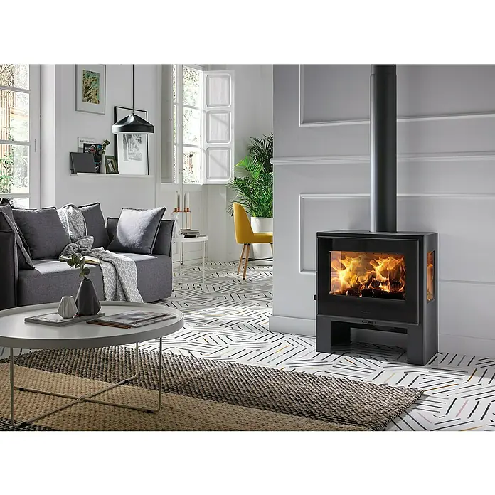 Panadero Kaminofen Amalfi 3V Ecodesign - 8 kW, Raumheizvermögen: 240 m³, Material Verkleidung: Stahl, Schwarz Metallic - Gemütliches Wohnzimmer mit modernem Kaminofen, der eine warme Atmosphäre schafft. Der Kamin ist ein echter Hingucker im Raum.