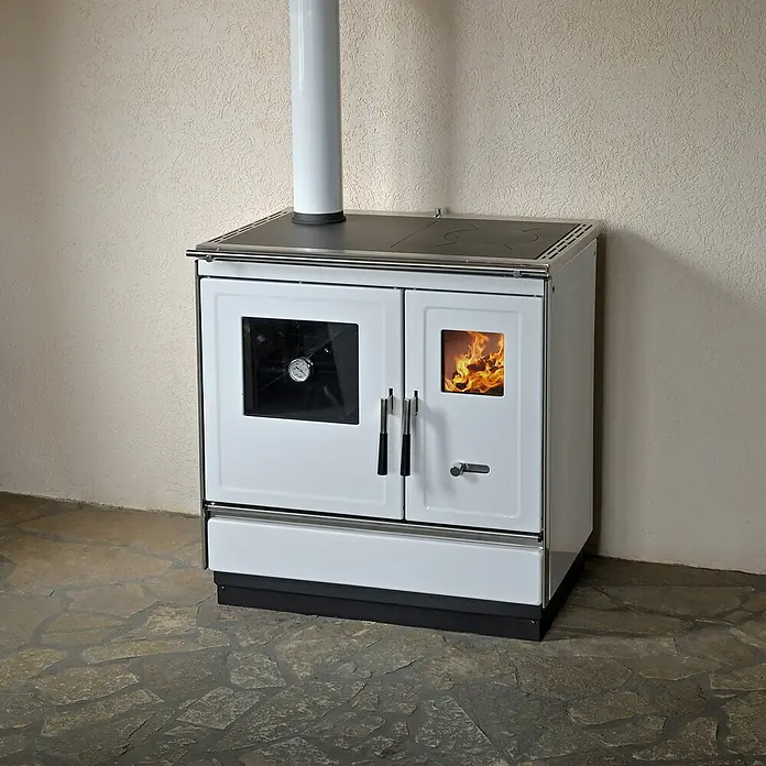 Haas+Sohn Küchenherd HSH 81 - Weiß, Ausführungseigenschaft: Ofen Links, 7,4 kW - Ein weißer Holzofen mit Kochfeld und Ofenrohr vor einer Wand. Das Feuer brennt sichtbar im Ofen.