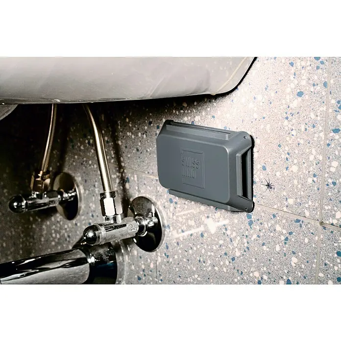 Swissinno Natural Control Trampa para parásitos - Trampa adhesiva, 2 ud. - La imagen muestra un insecticida Swiss Inno gris montado en una pared de baño junto a una conexión de inodoro.