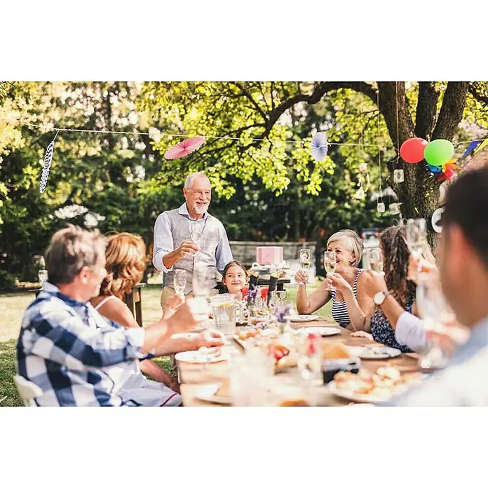 Swissinno Natural Control Cebo de recambio - Avispas, 2 ud. - Un grupo de personas celebrando al aire libre con una copa de vino espumoso en la mano, rodeados de decoración festiva y comida deliciosa.