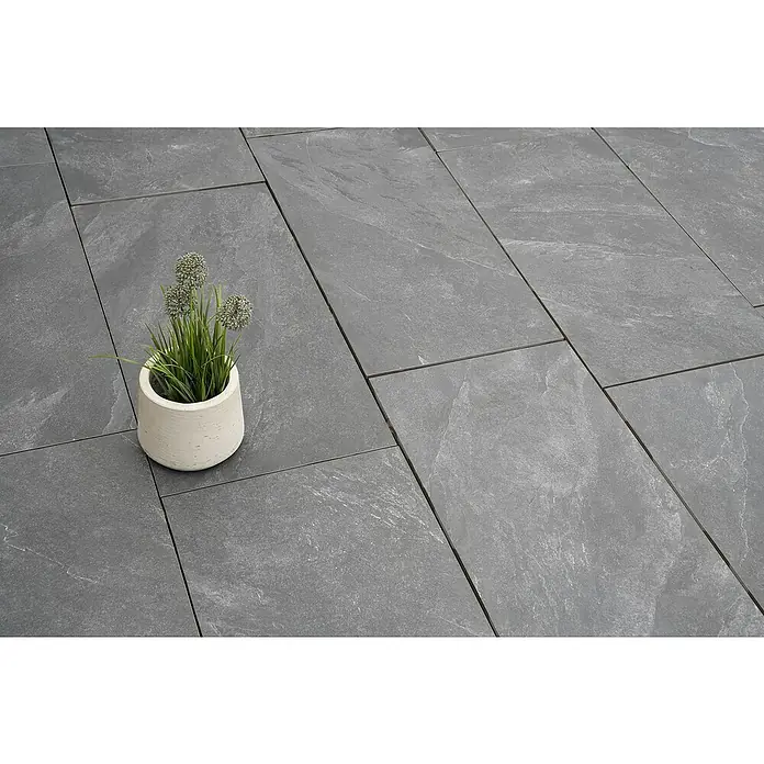 Diephaus Terrassenplatte Columbia - 80 x 40 x 4 cm, Core Basalt, Beton - Nahaufnahme eines weißen Topfes mit grünen Pflanzen auf grauen Steinplatten, ideal für Garten- und Terrassendesign.