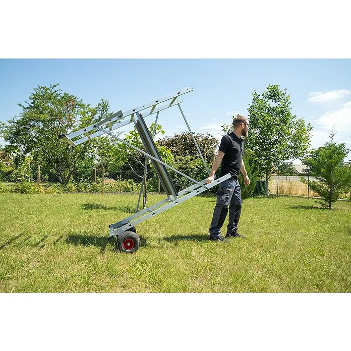 Hailo Leitergerüst HobbyStep H3 - Arbeitshöhe: 300 cm, Breite Plattform: 100 cm, Länge Plattform: 45 cm - Eine Person schiebt einen Hailo Leiterlift auf einem Rasen. Der Leiterlift hat Räder und ist grau.