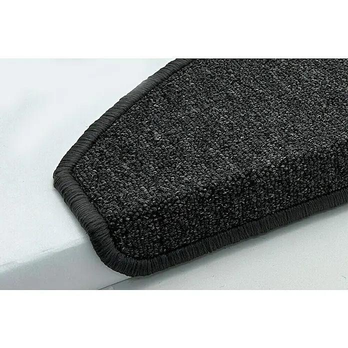 Stufenmatte Delta - 22 cm x 65 cm x 5 mm, Anthrazit - Nahaufnahme eines grauen Teppichs mit Umrandung, der auf einer hellen Oberfläche liegt. Ideal für Treppen und Flure.