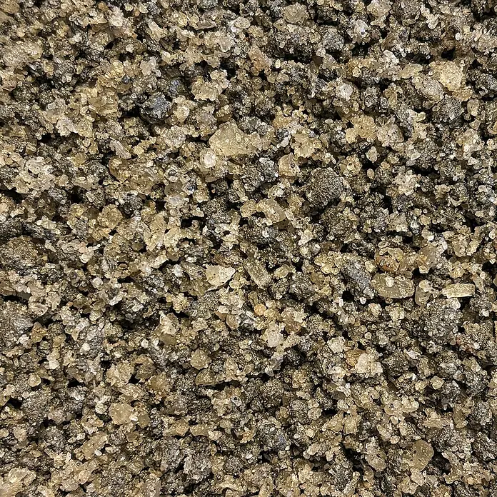Hamann Mercatus Auftau- & Streusalz - Lavagemisch - 25 kg - Nahaufnahme von grobem Salz, das eine Mischung aus dunklen und hellen Kristallen zeigt. Eine Textur von natürlichen, unbehandelten Salzkristallen.
