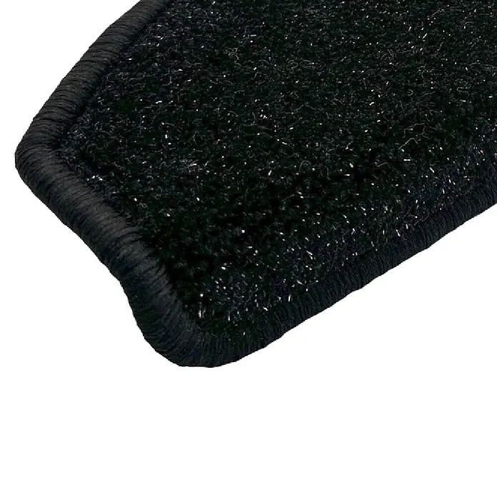 Stufenmatte Bravo - 15 Stk., 22 x 65 cm, 100% Polypropylen, Schwarz - Nahaufnahme einer schwarzen Teppichstufe mit abgerundeten Kanten, ideal für Treppen, die Schutz und Stil bieten.