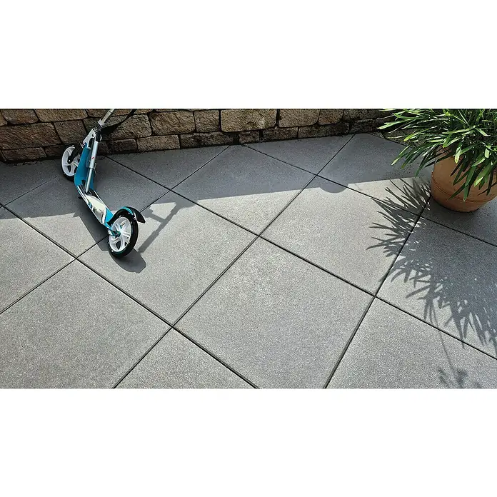 Diephaus Terrassenplatte Redding - 60 x 60 x 4 cm, Quarz, Beton - Scooter und Blumentopf stehen auf grauen Pflastersteinen und bilden eine ästhetische Außenszene mit klaren Linien und Schatten.