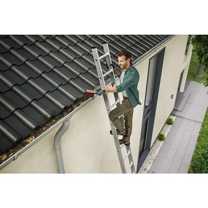 Hailo Anlegeleiter S60 ProfiStep uno 18 Sprossen - Anzahl Tritte: 18 Stk., Arbeitshöhe: 595 cm, Belastbarkeit: 150 kg, Aluminium - Ein Mann reinigt eine Dachrinne mit einer Bürste von einer Leiter aus. Er trägt eine grüne Jacke und braune Hosen.