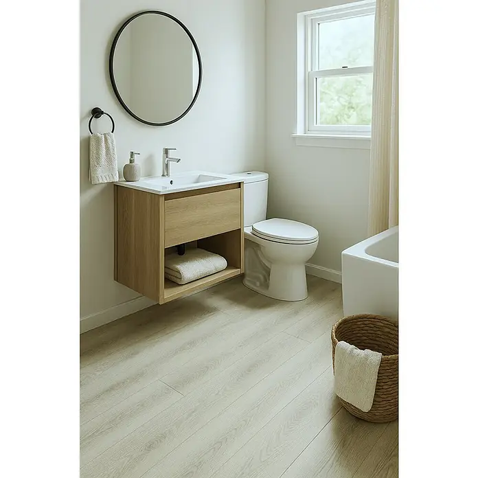 Suelo vinílico SPC Legendary Tree - 1.220 x 180 x 5 mm, Gris, Resistente al agua - Un baño luminoso con un moderno tocador con textura de madera, un espejo redondo y un inodoro blanco.