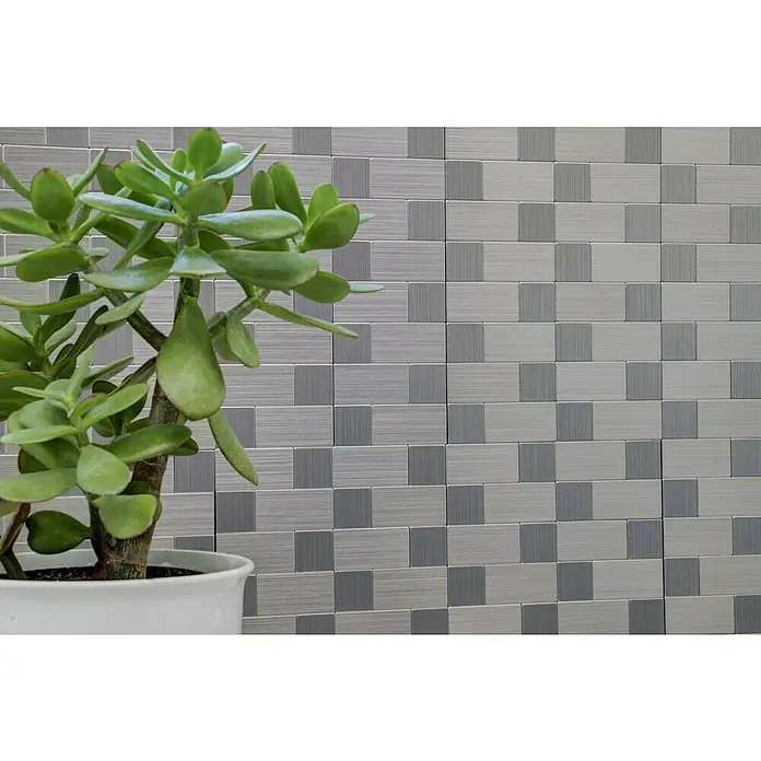 Selbstklebemosaik SAM 4MM87 - 30,5 x 30,5 cm, Silber, Glänzend - Nahaufnahme einer Zimmerpflanze in einem weißen Topf, vor einem Hintergrund aus grauen Wandfliesen mit einem modernen Design.