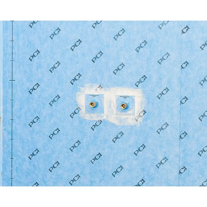 PCI Pecitape Dichtmanschette 10 x 10 - 10 x 10 cm - Nahaufnahme einer Wand mit zwei goldenen Wasseranschlüssen, eingebettet in eine blaue Abdichtungsbahn mit PCI-Muster.