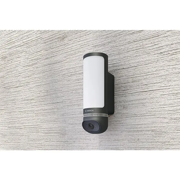 Bosch Smart Home Überwachungskamera Eyes II -  - Außenleuchte mit integrierter Überwachungskamera von Bosch an einer Wand. Die Leuchte ist länglich und spendet helles, weißes Licht.