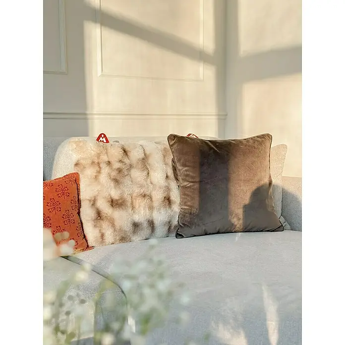Montandor Heizkissen Wärmekissen - 45 x 45 cm, Taupe - Nahaufnahme von dekorativen Kissen in verschiedenen Texturen auf einem Sofa, die für eine gemütliche und stilvolle Atmosphäre sorgen.