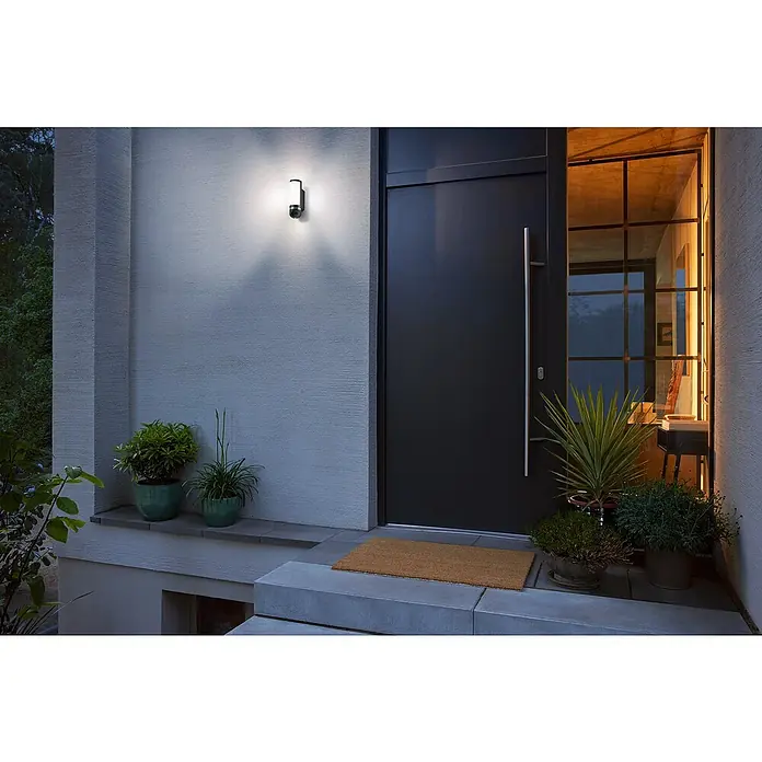 Bosch Smart Home Überwachungskamera Eyes II -  - Eine moderne Außenleuchte neben einer Haustür, die den Eingangsbereich stilvoll beleuchtet.
