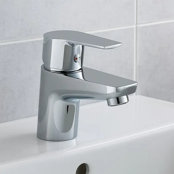 Clever Eno-X Grifo de lavabo 100 - Cromo - Primer plano de un grifo cromado brillante sobre un lavabo blanco con azulejos al fondo.