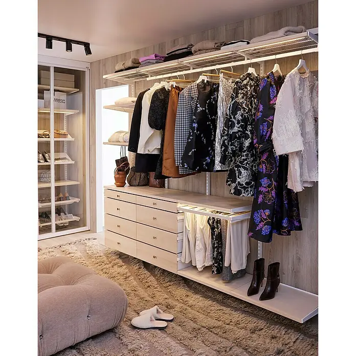 Elfa Décor+ by Elfa Schubladenfront - L x B x H: 1,5 x 60,4 x 8,8 cm, Braun - Elegantes begehbares Ankleidezimmer mit Schränken, Regalen, Schubladen und Kleiderstangen, beleuchtet mit warmen Lichtern.