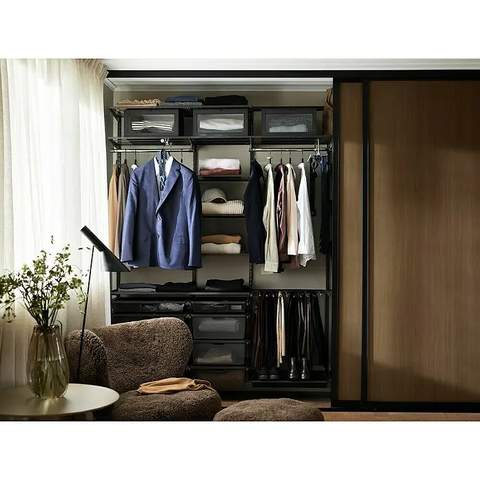 Elfa Classic by Elfa Korbauszug - L x B x H: 40 x 60 x 2,8 cm, Graphit - Ein begehbarer Kleiderschrank mit Kleidung, Aufbewahrungsboxen und einem Schrank mit Schiebetüren. Ein gemütlicher Sessel steht davor.