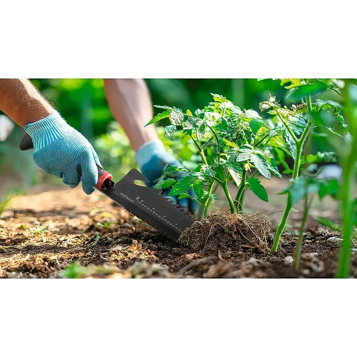 Easymaxx Schaufel Mulfifunktion 4-in-1 - Breite: 110 mm, Schwarz - Nahaufnahme eines EASYMAXX-Gartenwerkzeugs, das zum Pflanzen von Setzlingen in einem Garten mit blauen Gartenhandschuhen verwendet wird.