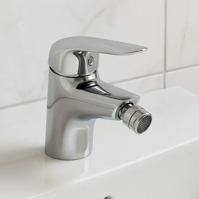 Cosmobath Halton Grifo monomando de bidé - Cromo, Brillante - Un grifo de bidé cromado brillante se encuentra sobre un lavabo blanco con un fondo de azulejos. El grifo presenta un diseño moderno y elegante.