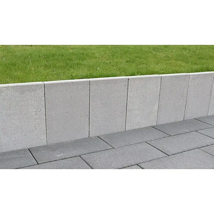Christoph L-Stein - 25 x 22 x 39,8 cm, Stärke: 4,3 cm - Nahaufnahme von grauen Pflastersteinen, die einen Gehweg und eine niedrige Mauer bilden, wobei der Fokus auf der klaren Linienführung und Textur liegt.