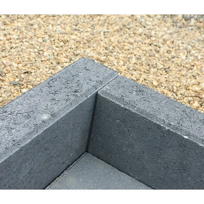 Christoph Randstein - 100 x 7 x 17 cm, Anthrazit, Beton - Detailaufnahme von grauen Pflastersteinen, die eine Ecke bilden, mit Kies im Hintergrund. Ideal für Garten- und Landschaftsbauprojekte.