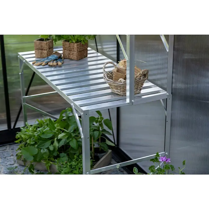 Halls Gewächshaus-Tisch - 120,8 x 76 cm, Aluminium, Eine Ablageebene - Nahaufnahme eines silbergrauen Gewächshaustisches mit Pflanzen und Gartenzubehör.