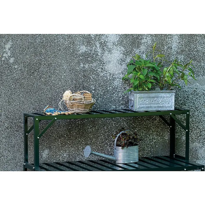 Halls Aufsatz für Gewächshaus-Tisch - 120,8 x 26 x 3,7 cm, Grün, Passend für: Halls Tische ( 1 Ablagefläche) - Gartenszene mit Metallregal, bepflanztem Metalleimer, Korb mit Gartenzubehör und gusseiserner Gießkanne vor grauer Wand.