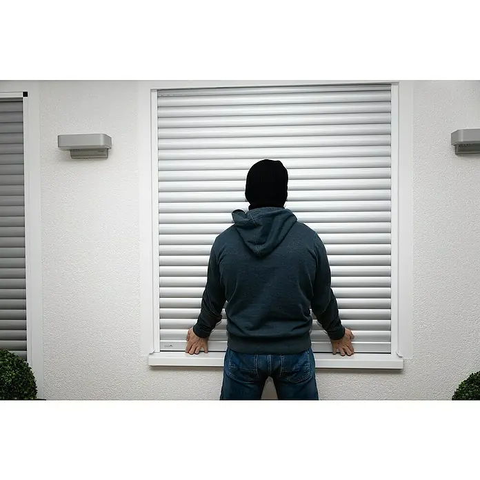 Schellenberg Klemmsicherung - Geeignet für Profil-Deckhöhe: Ab 45 mm, 2 Stk. - Ein Einbrecher versucht, einen Rollladen an einem Fenster aufzubrechen, um in ein Haus einzudringen.