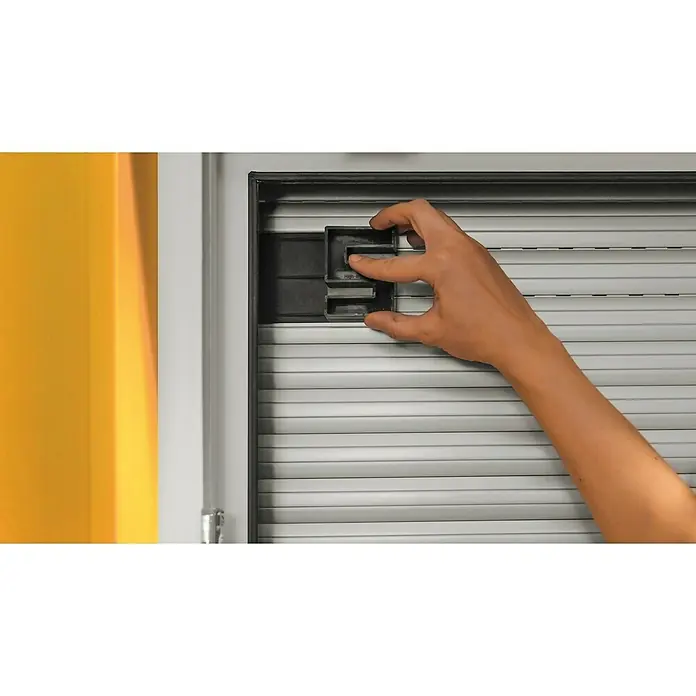 Schellenberg Hochschiebesicherung - 2 Stk. - Eine Hand befestigt eine schwarze Kunststoffhalterung an einem Rollladen, um die Funktionalität zu gewährleisten.