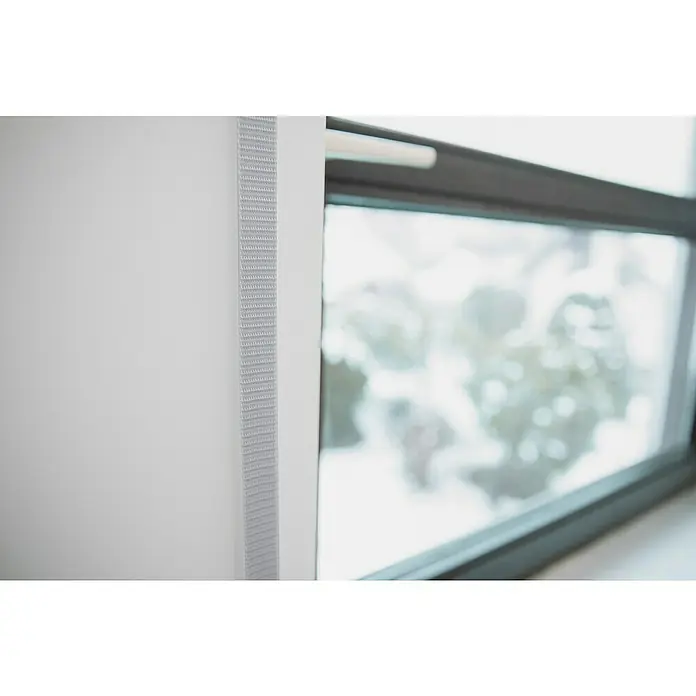 Schellenberg Rollladengurt Maxi - Grau, Länge: 6 m, Gurtbreite: 23 mm - Nahaufnahme eines modernen, weißen Möbels neben einem Fenster, das einen verschwommenen Blick auf die Außenwelt bietet. Das Design ist minimalistisch und hell.