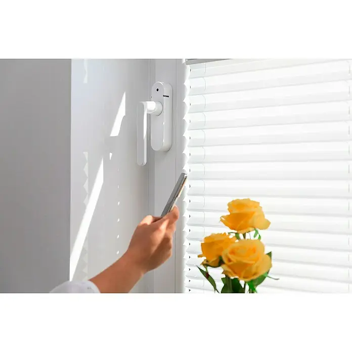 Schellenberg Smart Home Funk-Alarmgriff - DIN Anschlag: Links/Rechts, Weiß - Nahaufnahme eines Fensters mit Jalousien, das mit einem Smartphone bedient wird, neben gelben Rosen.