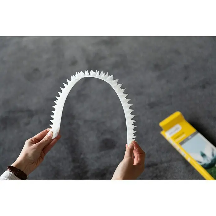 Schellenberg Taubenschutz - L x B x H: 49 x 4,3 x 2 cm - Eine Person hält einen weißen Vogelabwehr-Spikes-Streifen, der effektiv Vögel fernhält und Gebäude schützt.