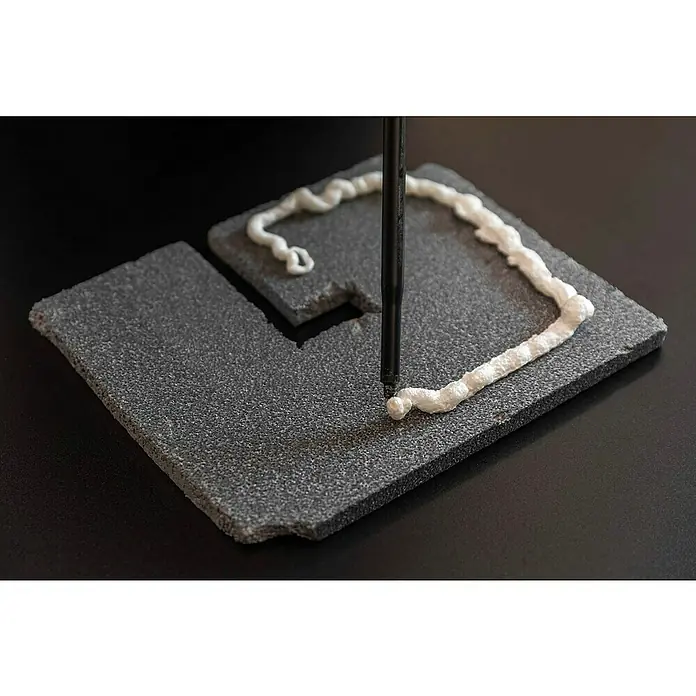 Schellenberg Rollladenkasten-Dämmmatte Seitenteil - 300 x 360 x 15 mm - Grauer Schaumstoff wird mit einem Stift und weißem Dichtmittel bearbeitet. Ein interessantes Bastelprojekt oder eine Reparaturidee.