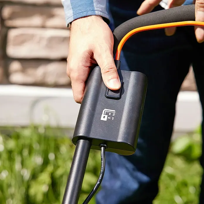 Litheli U20 Akku-Rasenmäher - 20 V, Ohne Akku, Schnittbreite: 33 cm - Nahaufnahme eines Rasenmähers mit einer Hand am Bedienfeld. Das Gerät ist schwarz und hat eine orangefarbene Schnur.