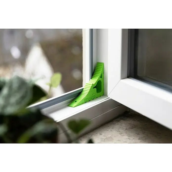 Schellenberg Tür- & Fensterstopper - Grün - Ein grüner Schellenberg-Fensterspaltlüfter wird in einem weißen Fensterrahmen gezeigt, um die Belüftung zu verbessern.