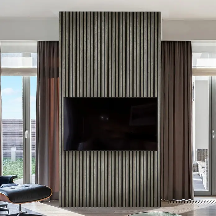 FibroTech Akustikpaneel Stone - Cement Stone, L x B x S: 2.440 x 520 x 18 mm - Moderne Wohnzimmergestaltung mit einem großen schwarzen Flachbildfernseher an einer Akzentwand mit vertikalen Holzlamellen und Vorhängen.