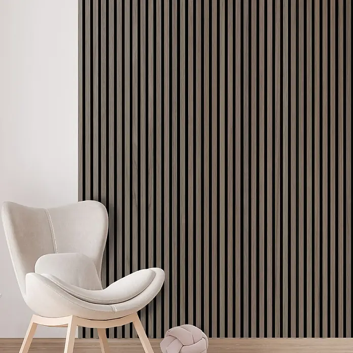FibroTech Akustikpaneel Premium - Walnut, 2.440 x 605 x 22 mm - Elegantes Interieur mit einem bequemen Sessel und einer stilvollen Akustikwand aus Holzlatten für eine moderne Raumgestaltung.
