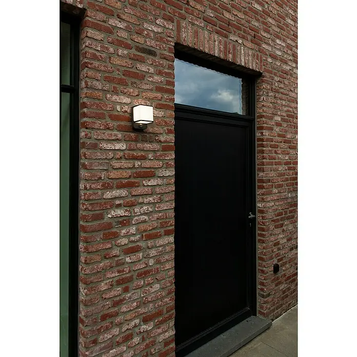Lutec Doblo LED-Sensor-Außenwandleuchte - 14 W, L x B x H: 10,3 x 11 x 146 cm, Anthrazit - Schwarze Tür mit einem Fenster und einer quadratischen Außenleuchte an einer Ziegelwand.