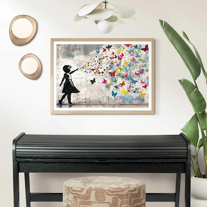 Reinders Holzrahmen - 50 x 70 cm, Buche - Ein gerahmtes Banksy-inspiriertes Kunstwerk mit einem Mädchen und bunten Schmetterlingen, das über einem schwarzen Schreibtisch mit Hockern hängt.
